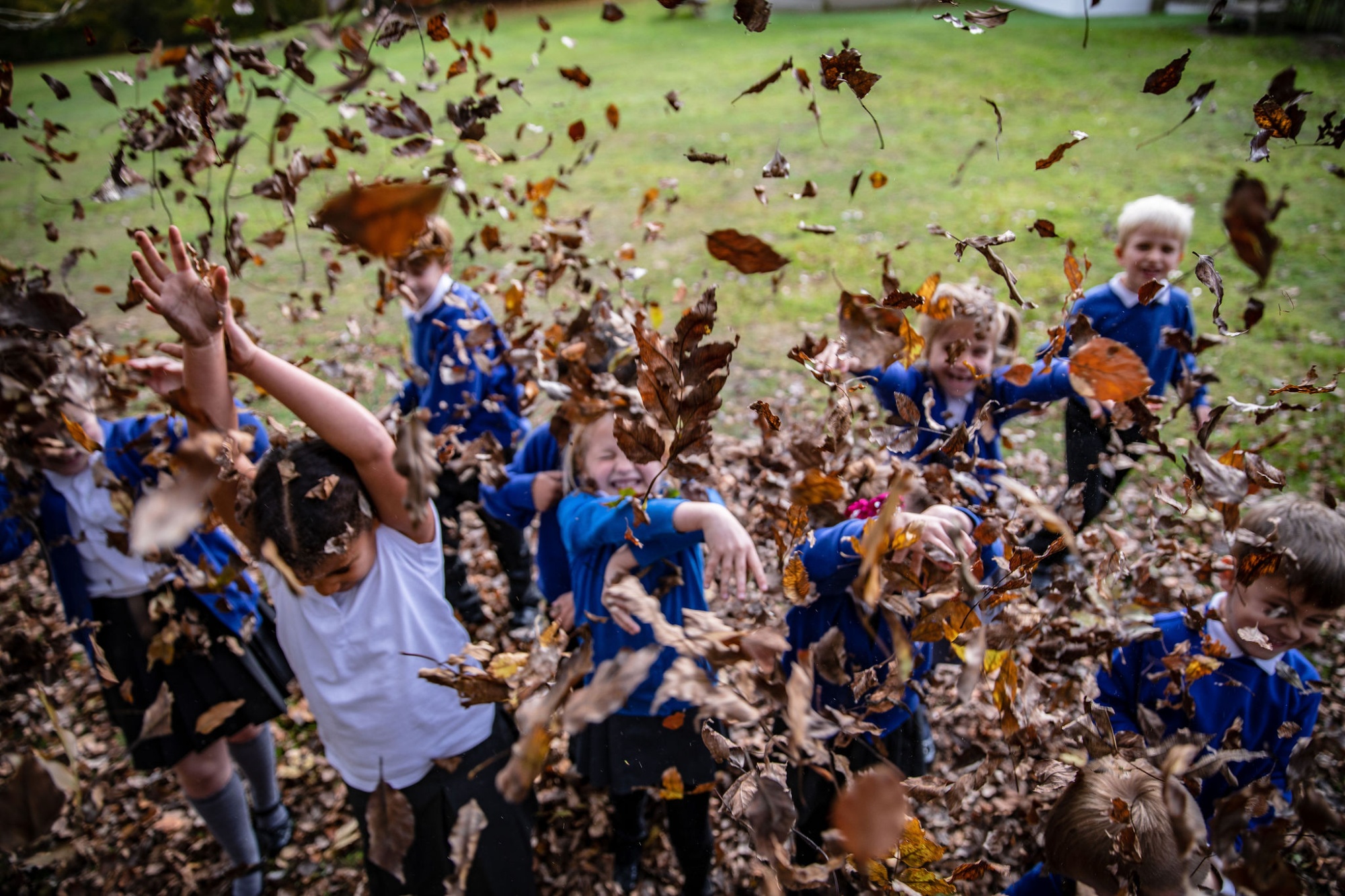 Children playing with leaves in a school playground